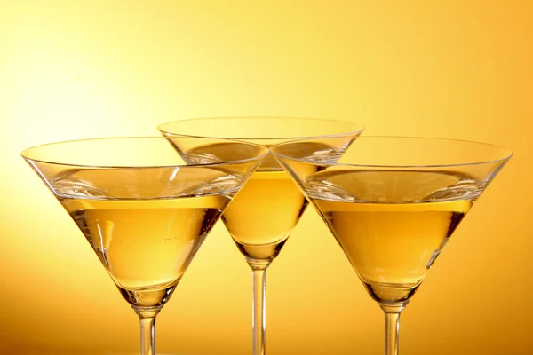 Три стакана мартини на желтом фоне — стоковое фото