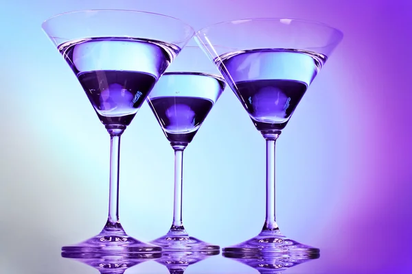 Tres vasos de martini sobre fondo morado — Foto de Stock