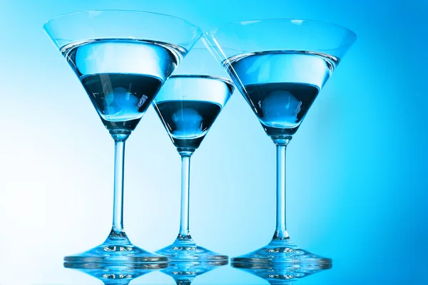 Trzy kieliszki dla martini na niebieskim tle — Zdjęcie stockowe