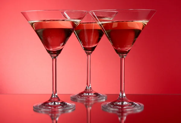 Three martini glasses on red background — Stockfoto