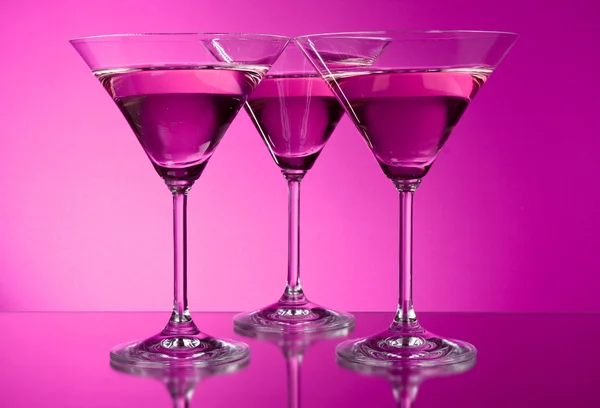 Drei leere Martini-Gläser auf violettem Hintergrund — Stockfoto