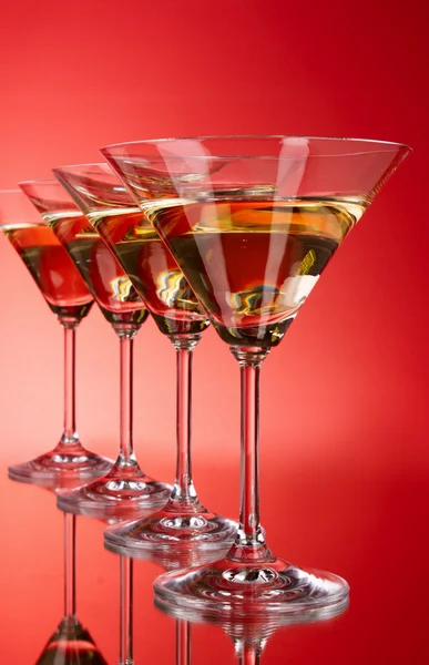 Cztery kieliszki dla martini na czerwonym tle — Zdjęcie stockowe