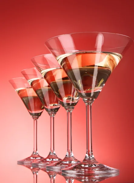 Four martini glasses on red background — Stock Photo, Image