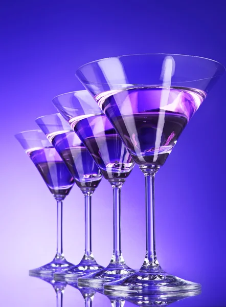 Cztery kieliszki dla martini na niebieskim tle — Zdjęcie stockowe