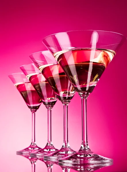 Quatro copos de martini no fundo vermelho — Fotografia de Stock