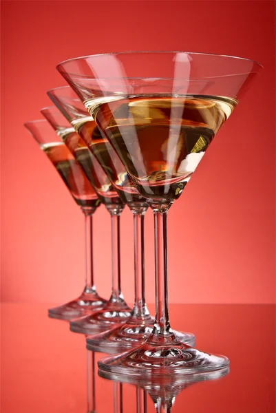 A few glasses of martini on a red background — Stock Photo, Image