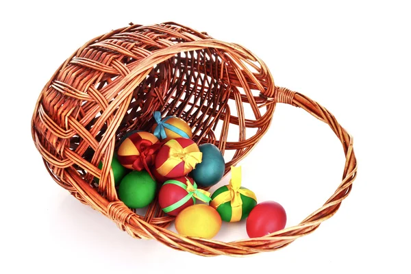 Cesta de mimbre con huevos de Pascua aislados en blanco — Foto de Stock