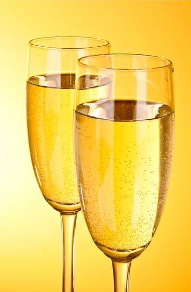 Dwie szklanki szampana na żółtym tle — Zdjęcie stockowe