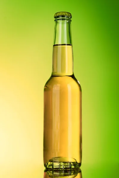 Bottle with alcohol on green background — Stock fotografie