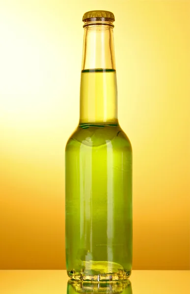 Fles met een groene alcoholische drank op een gele achtergrond — Stockfoto