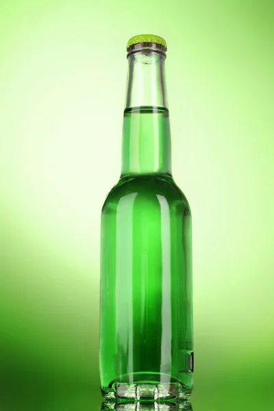 Бутылка с алкоголем на зеленом фоне — стоковое фото