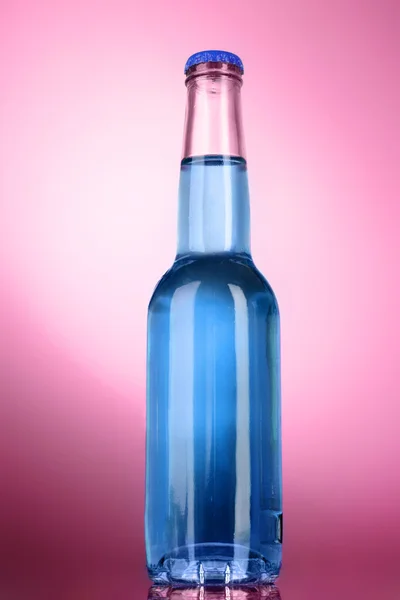 Пляшка з алкоголем на рожевому фоні — стокове фото
