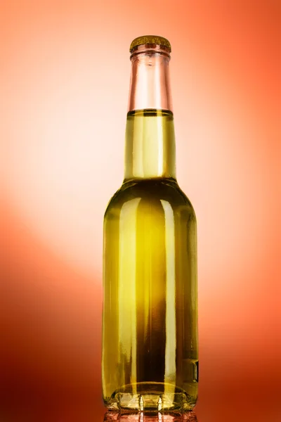 Пляшка з алкоголем на помаранчевому фоні — стокове фото