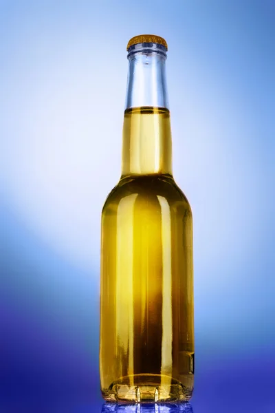 Garrafa com álcool sobre fundo azul — Fotografia de Stock