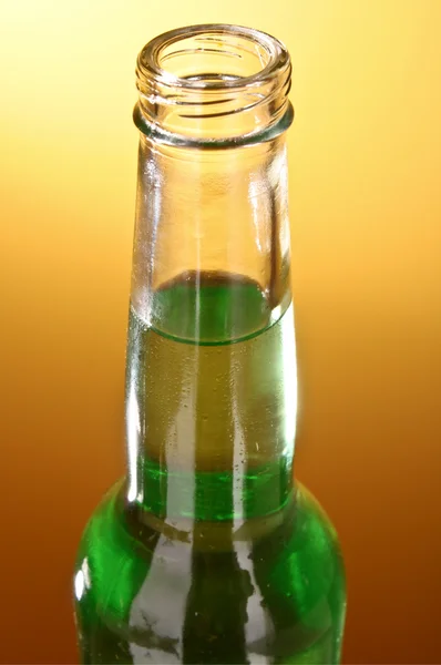 Flaska med en grön drink på gul-brun bakgrund — Stockfoto