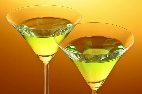 Glas med en grön alkoholhaltig dryck till en gul-brun ba — Stockfoto