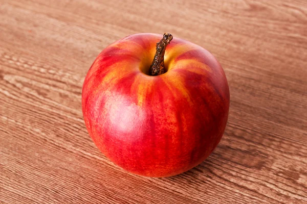Красное яблоко на деревянной текстуре — стоковое фото