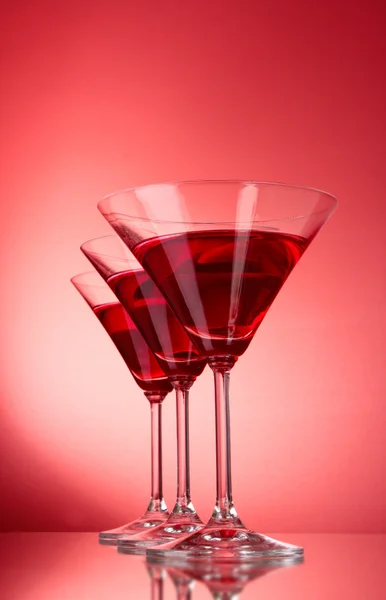 Три бокала с мартини на красном фоне — стоковое фото