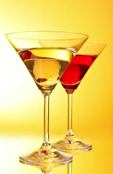 Copos com bebida alcoólica em fundo amarelo-marrom — Fotografia de Stock