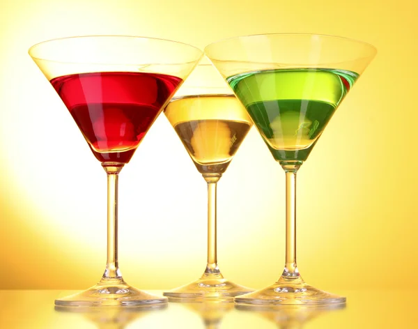 Несколько стаканов алкогольных напитков на желто-коричневом фоне — стоковое фото