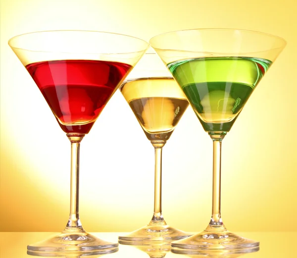 Несколько стаканов алкогольных напитков на желто-коричневом фоне — стоковое фото