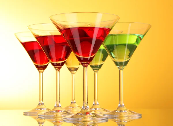 A few glasses of alcoholic drinks in a yellow-brown background — Stock Photo, Image