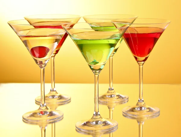 stock image A few glasses of alcoholic drinks in a yellow-brown background