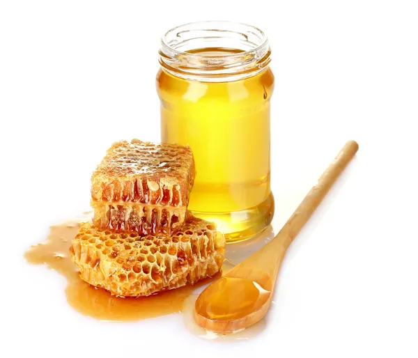美丽梳子、 勺子和蜂蜜在瓶子上白色隔离 — 图库照片