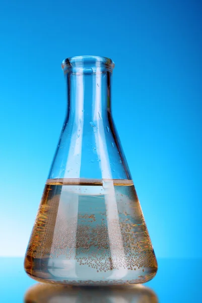 Conical flask on blue background — Stock Photo, Image