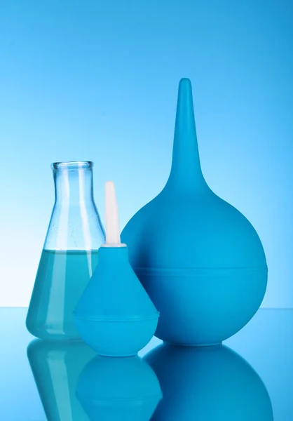 Blaue Gummibirne. clyster. Reagenzglas. auf blauem Hintergrund — Stockfoto