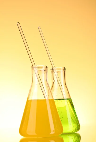 Laborgläser auf gelbem Hintergrund — Stockfoto