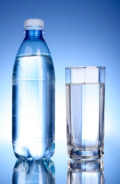 Şişe su ve mavi renkli cam — Stok fotoğraf