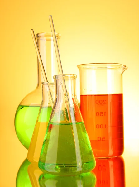 Vidros de laboratório sobre fundo amarelo — Fotografia de Stock