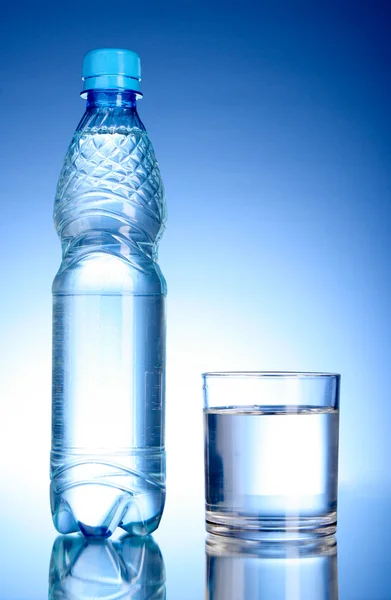 Bottle of water and glass on blue background — Stock Photo, Image