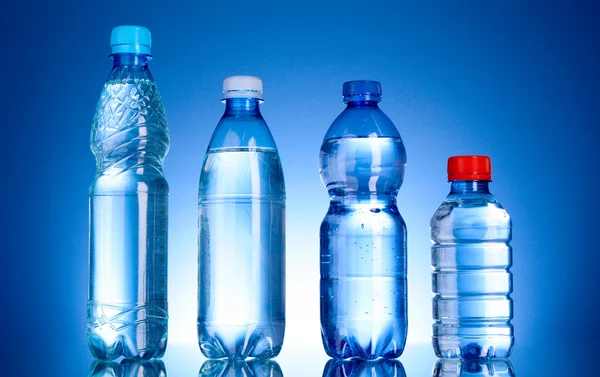Mavi arka planda su şişeleri — Stok fotoğraf