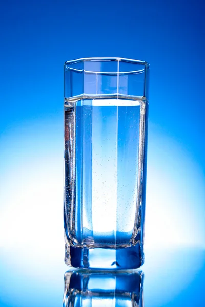 Glass of water on blue background — Stock Photo, Image