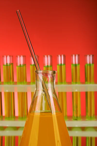 Vidrio de laboratorio sobre fondo rojo — Foto de Stock