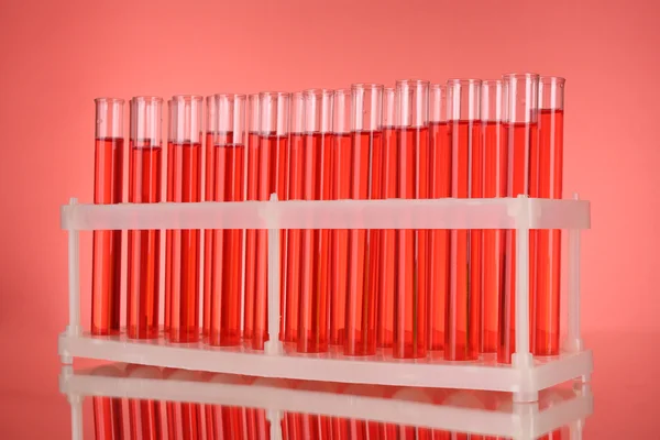 Tubos de ensayo sobre fondo rojo — Foto de Stock