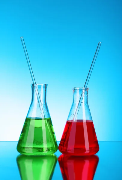 Cristalería de laboratorio sobre fondo azul — Foto de Stock