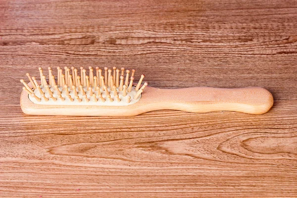 Hairbrush on wooden textured table — Stock Photo, Image