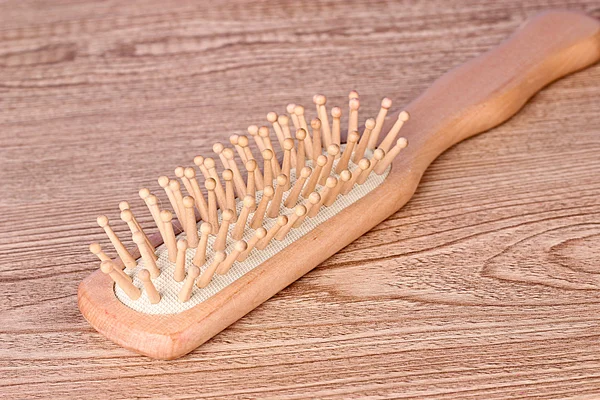 Ahşap desenli masa üzerinde saç fırçası — Stok fotoğraf