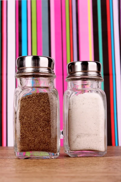 Salt and pepper shaker on color lines background — Stock Photo, Image