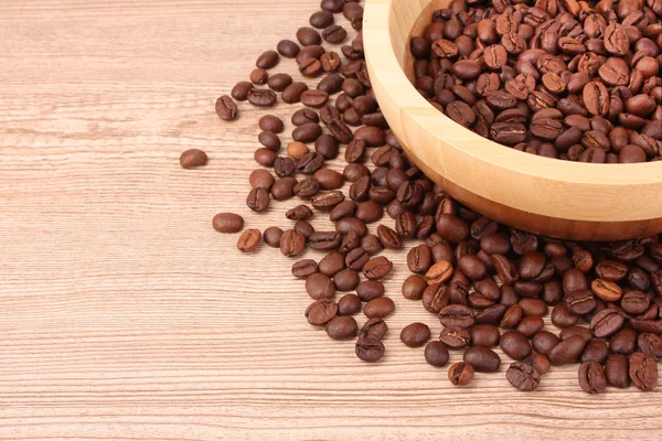 Teller mit Kaffeebohnen auf Holztisch — Stockfoto