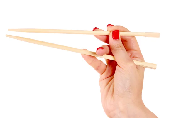 Женская рука и деревянные палочки для еды — стоковое фото