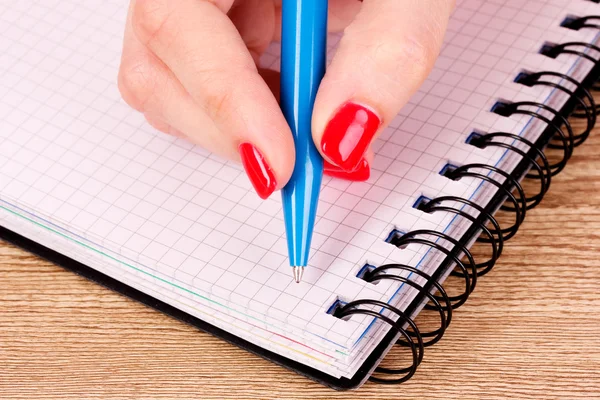 Woman's hand and notepad — Stock Photo, Image