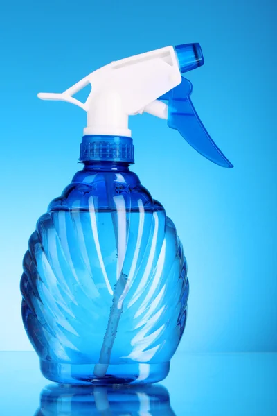 Bottiglia spray blu su sfondo blu — Foto Stock
