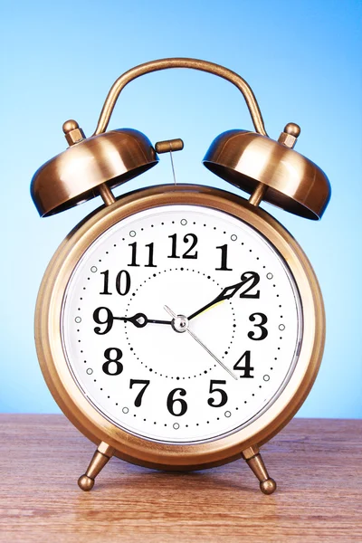 Old alarm-clock on blue background Stock Picture
