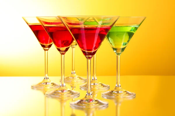 A few glasses of alcoholic drinks in a yellow-brown background Stock Picture