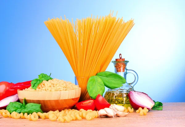 Spaghetti med vitlök, lök, kryddor och basilika på en gul tillbaka — Stockfoto