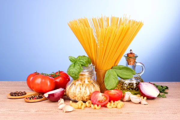 Espaguete com alho, cebola, temperos e manjericão em umas costas amarelas — Fotografia de Stock